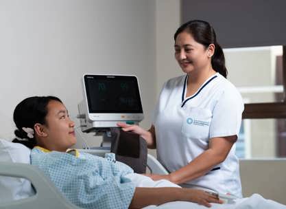 A caregiver checking on a patient to demonstrate the level of care provided in a Long-Term Care Facility vs Nursing Home.